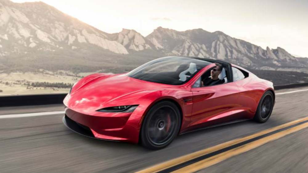 Tesla Roadster 2025, une voiture électrique de sport avec un design aérodynamique, présentant des performances exceptionnelles et des caractéristiques innovantes sur une route dégagée."